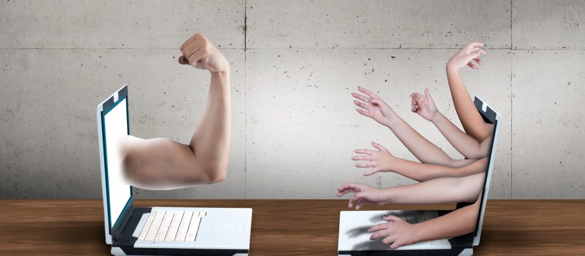 Two laptop with arms pointed to eachother. Cyber bully concept. Online conflict between people. Human rights argue.