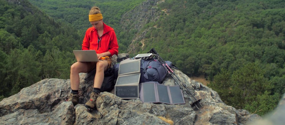 Caucasian,Female,Hiker,Sitting,On,A,Rock,While,Working,On